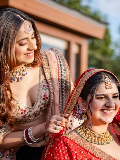 A tender moment between sisters, as one helps the bride with her veil. It's these small, supportive gestures that tell the real story.