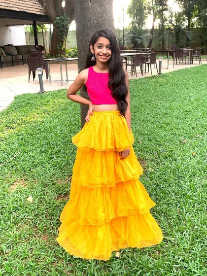 This outfit brings together a bright pink crop top and a sunny yellow tiered net skirt for a look that is pure fun. It’s a perfect example of my Indo-Western designs, combining bold colors and playful textures for a standout party look.