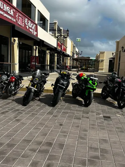A wide shot of several motorcycles parked along our clean, paved walkways, with the Kritunga restaurant visible in the background.