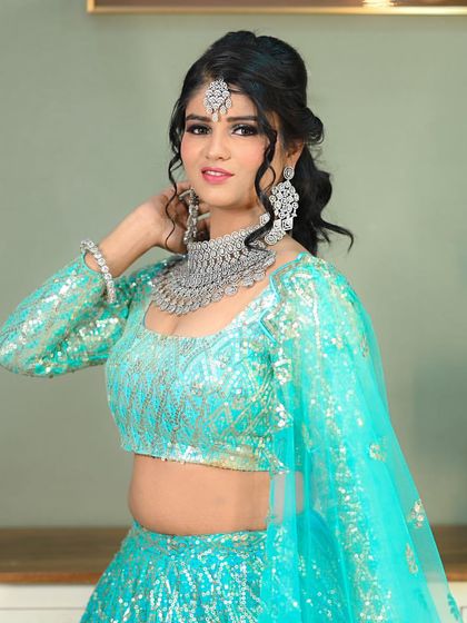 A modern and fresh bridal or sangeet look, featuring a sparkling turquoise lehenga and diamond jewelry.