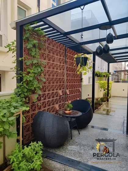 This cozy corner features a terracotta jali wall that provides privacy and ventilation for a small seating area. The natural clay material and intricate pattern add a warm, earthy, and artistic touch.
