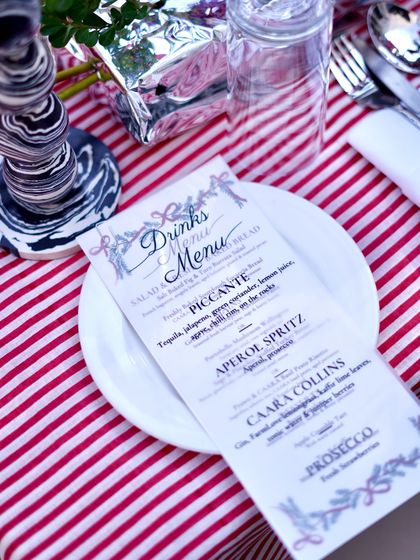The beautifully designed menu for our Christmas brunch, placed on a festive red-and-white striped tablecloth. Every detail, from the menu to the table setting, is carefully considered.