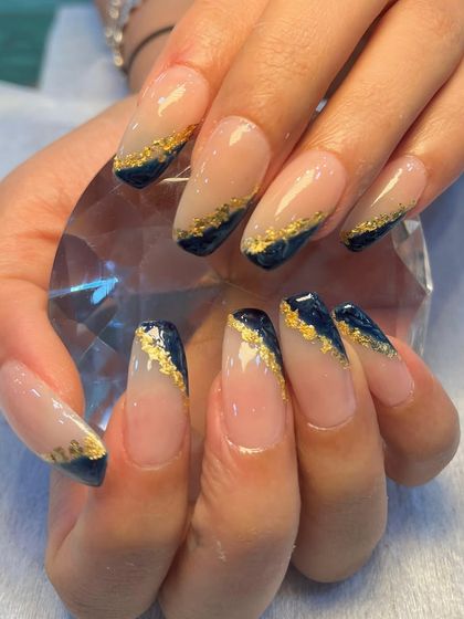 Dipped in midnight, dusted with gold. This luxurious design features a deep blue base with a diagonal sweep of gold foil, creating a rich and elegant look on long, square-shaped extensions.