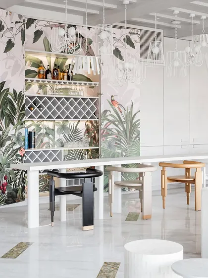 We love adding an element of surprise to our designs. This custom bar at House No. 7 is concealed behind wall paneling, opening up to reveal a vibrant, tropical paradise inspired by Birds of Paradise wallpaper.