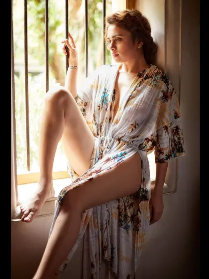 This photoshoot with Amruta Khanvilkar captures the timeless feeling of summer. The flowing, tropical print robe and the soft window light create a serene and elegant mood. This is an example of editorial styling where the outfit, setting, and model come together to tell a beautiful visual story.