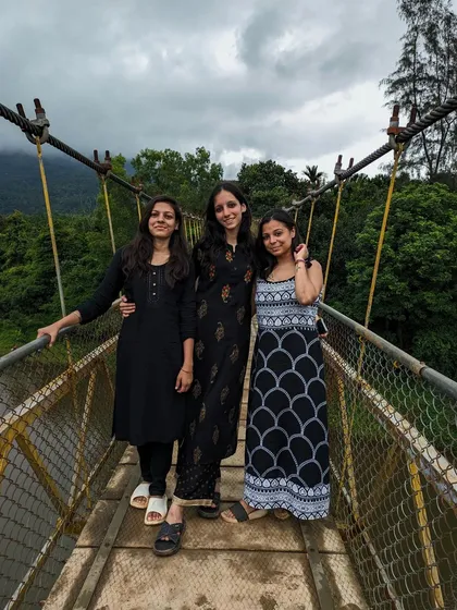 Three friends on the hanging bridge near the Netravathi trek base, a popular photo spot.