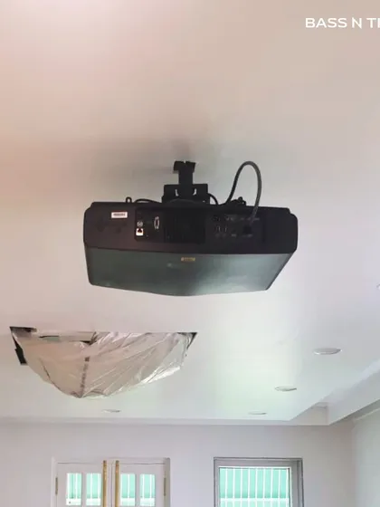 A ceiling-mounted 4K projector during installation. Proper placement is critical for image quality, and we handle all the technical aspects to ensure a perfect picture.