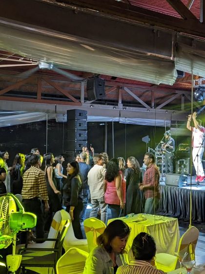 A side view of the stage and audience at the Karnataka Golf Association. It shows the engaged crowd and the lively atmosphere we create.