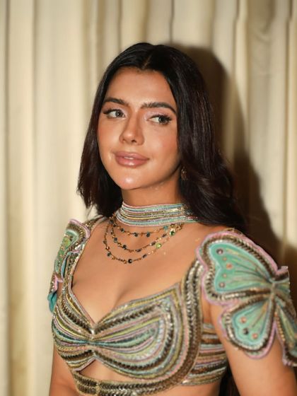 A chic and modern party look. The makeup is polished and sophisticated, with a flawless base and subtly defined features.