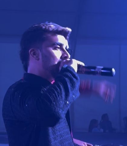 On the mic at a Dandiya festival, hyping up the massive crowd. For large-scale events, connecting with the audience is key to maintaining the energy.