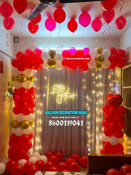 A focused look at the balloon arch and fairy light curtain from a romantic room decoration. The combination of red, white, and gold balloons creates a classic and festive atmosphere.