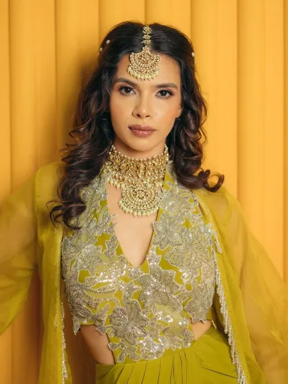 A beautiful Mehendi look with soft pink shimmer on the lids. This touch of color adds charm and grace, perfectly complementing the intricate bridal jewelry.