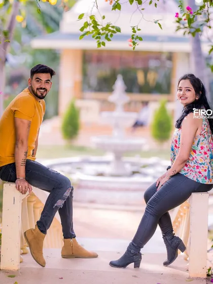 A casual and relaxed portrait of a couple sitting by the garden fountain.
