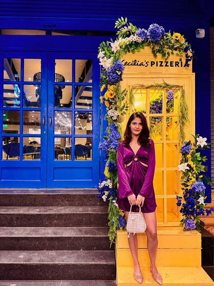 A 'fit check' in a vibrant purple satin mini dress. The cutout details and bell sleeves add a trendy touch, making it a great choice for a dinner date or a night out.