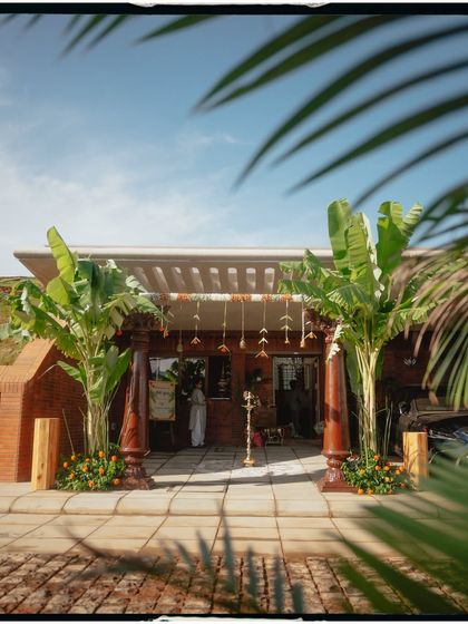 A beautiful shot of the house entrance, decorated with traditional pillars and banana plants.