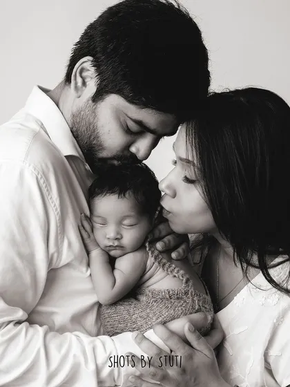 A black and white portrait of a new family, filled with love and tenderness.