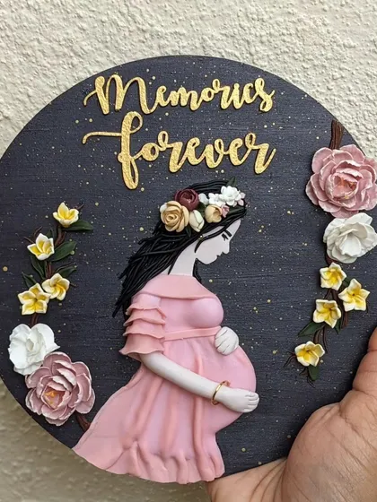A close-up of the maternity wall art, showing the delicate flowers and the gentle posture of the mother-to-be. Every detail is sculpted by hand.