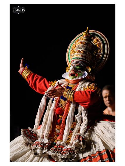 A side profile of a Kathakali dancer, showcasing the elaborate headgear and expressive gestures that define this classical art form.