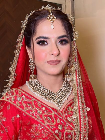 A close-up of this bride's classic look. The simple red bindi, winged eyeliner, and nude lipstick create a timeless and elegant aesthetic that never goes out of style.