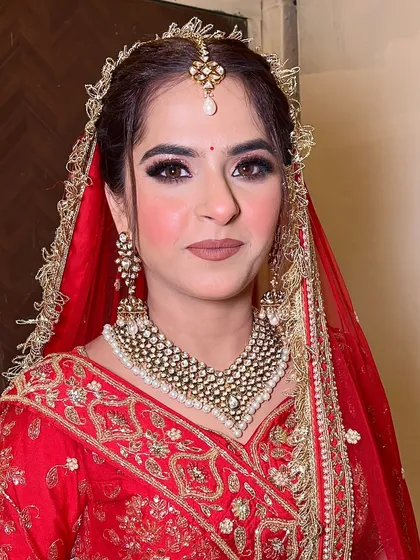 A close-up of this bride's classic look. The simple red bindi, winged eyeliner, and nude lipstick create a timeless and elegant aesthetic that never goes out of style.