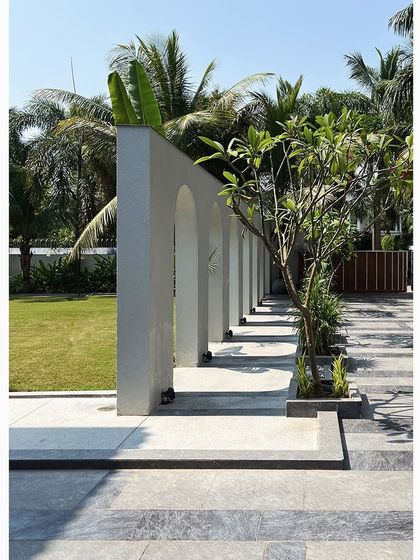 The strong afternoon sun creates a beautiful interplay of light and shadow along the arched walkway. The rhythmic pattern on the floor becomes a piece of ephemeral art in itself.