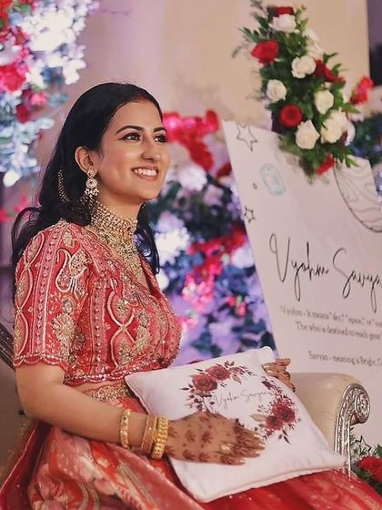 Shivani looking lovely at her son's naming ceremony. Her red lehenga is paired with soft, glowing makeup and loose curls.