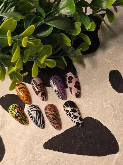A collection of various animal print nail art designs, from giraffe and leopard to zebra and cow print.