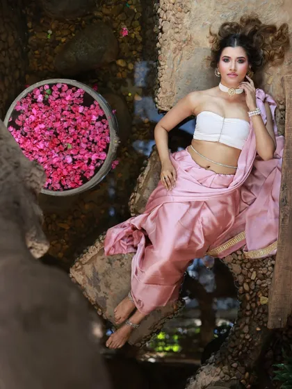 A beautiful overhead shot of the model lying by the water, with a basket of flowers nearby. This composition is rich in color and texture.