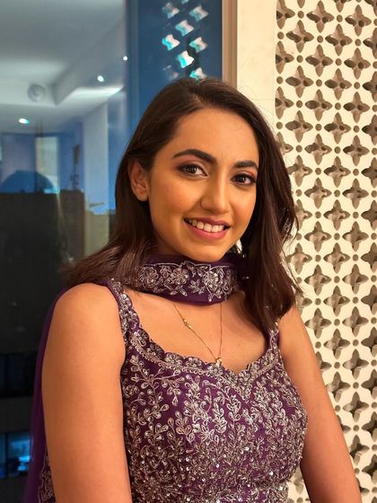 A happy client ready for a sangeet. The makeup is fun and youthful, with a bright smile to complete the look.