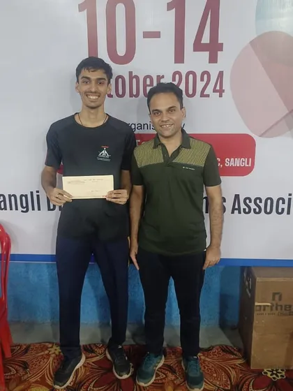 Our coach stands with Deepit Patil after his Men's Singles title win at the Maharashtra State Ranking Tournament, highlighting our successful coaching partnership.