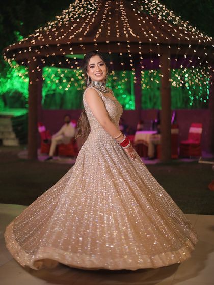 A full-length shot of the bride twirling in her shimmery gown at her reception, set against a beautifully lit gazebo.