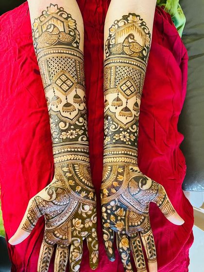 This design is a celebration of peacocks and jhumkas. These classic motifs are repeated throughout the hands and arms, creating a beautifully themed and traditional bridal mehendi.