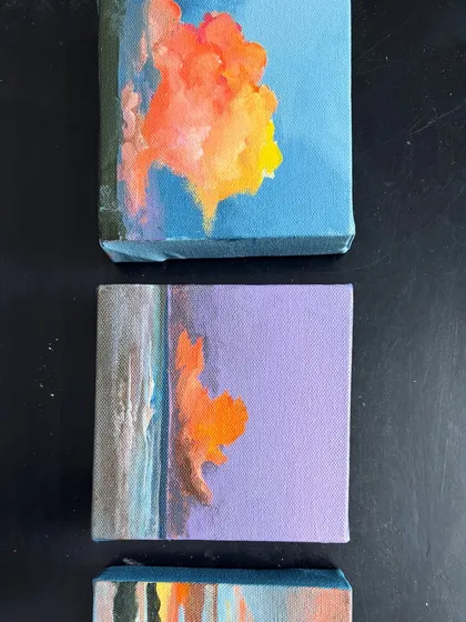 A close-up of two miniature paintings featuring vibrant, abstract clouds at sunset. Even on a small scale, I love to play with bold color and expressive brushstrokes.