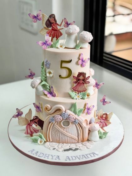 A magical fairy garden for a little princess turning 5. This two-tier fondant beauty is filled with whimsical details, from hand-crafted fairies and butterflies to a storybook fairy door.