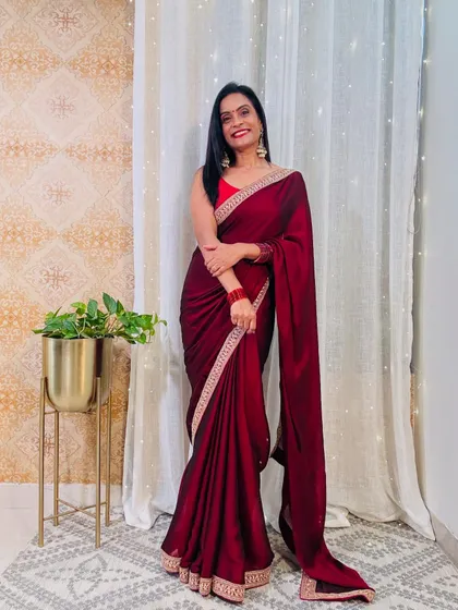 A deep maroon satin saree with an embroidered border. The rich color is very slimming and looks incredibly regal, perfect for a formal event.