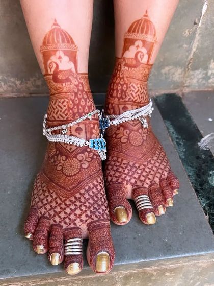 The rich, dark stain of this bridal feet mehendi looks stunning with the bride's traditional silver anklets and toe rings.