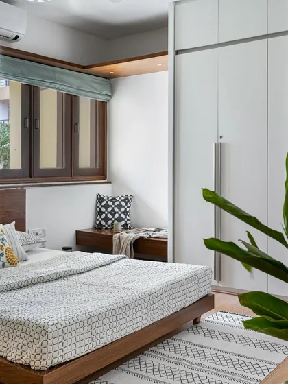This bedroom in our 'Pepper and Coffee' project features a cozy window seat with storage, nestled beside a floor-to-ceiling built-in wardrobe, making the most of the room's corner.