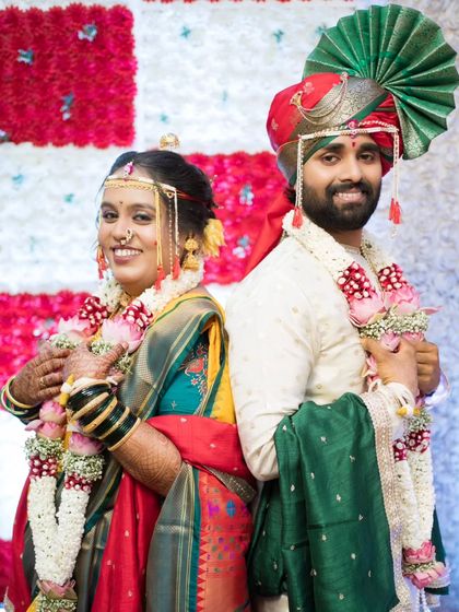 A fun back-to-back pose, with the couple showing off their wedding garlands.