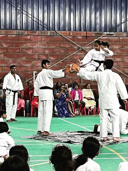 A black belt student executes a flying side kick to break a board during a demonstration. This showcases the spectacular and advanced skills that are achievable through our training syllabus.