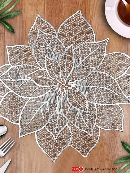 A beautifully styled top-down shot of a lace table mat. We create complete scenes with props like cutlery and tea to help customers visualize the product in their own home.