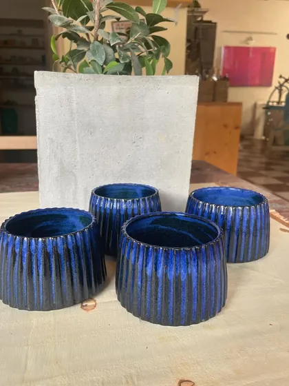 A collection of my handmade ceramic mugs, each with its own unique shape and glaze. The little coffee bean detail on the handle is a fun touch for coffee lovers.