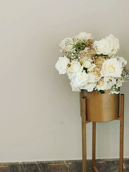 We provide minimalist floral decor that complements modern interiors. This arrangement of white roses in a sleek gold planter adds a touch of understated luxury to a home or corporate event.