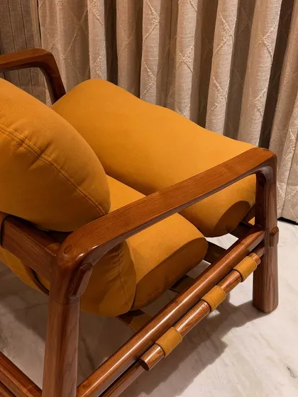 The details are everything. This close-up of my 'Marshmallow' Armchair shows the smooth Ashwood frame, the soft texture of the suede fabric, and the leather strap details that hold the cushions in place. It’s this level of micro-detailing and woodworking that I am passionate about.