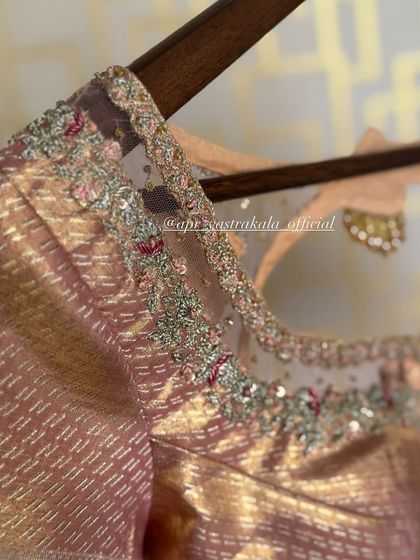 A dusty pink blouse with a sheer net yoke, adorned with delicate floral embroidery. This is a more contemporary take on the traditional bridal blouse.
