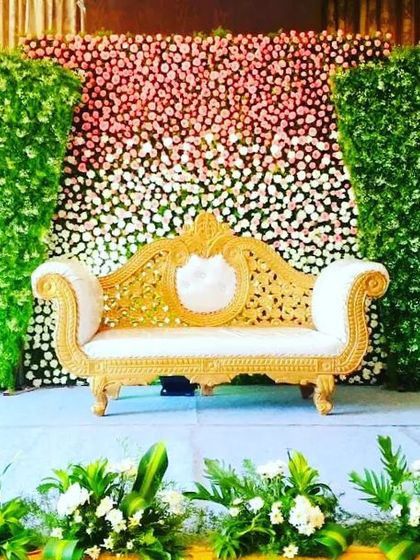 This engagement backdrop uses a central panel of ombre flowers, transitioning from pink to white, flanked by two green walls. The simple gold and white sofa keeps the focus on the colorful floral design.