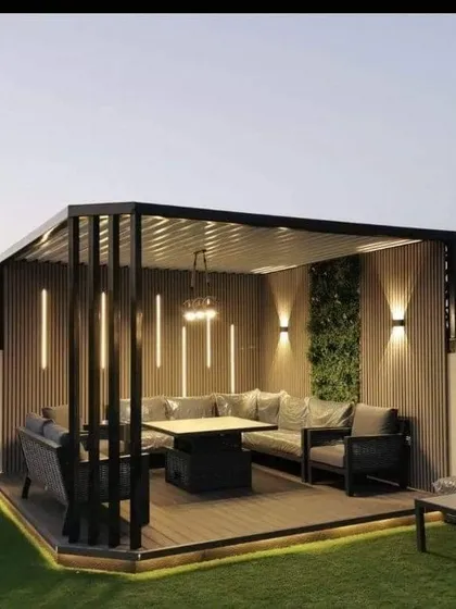 This rooftop terrace was converted into a luxurious outdoor lounge, complete with a modern pergola for shade. The design includes a large L-shaped sofa, integrated vertical lighting for dramatic effect, and a green wall accent, perfect for hosting and entertaining.