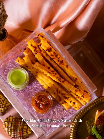 My Cheddar Chilli Cheese Straws are a crowd favorite. They are served here with a vibrant green dip and a rich sundried tomato pesto, making for a perfect party snack.