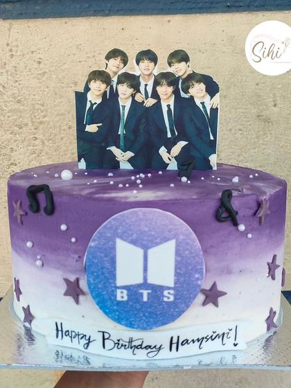 Smooth like butter. A BTS-themed cake for the ARMY. This purple ombre cake is decorated with the BTS logo, music notes, and an edible print of the band.