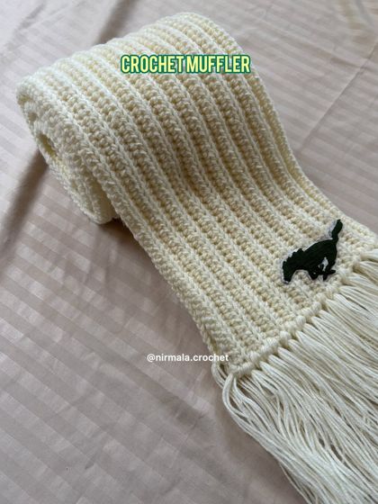 Another angle of the personalized cream muffler, showing the texture of the ribbed stitch and the custom logo.