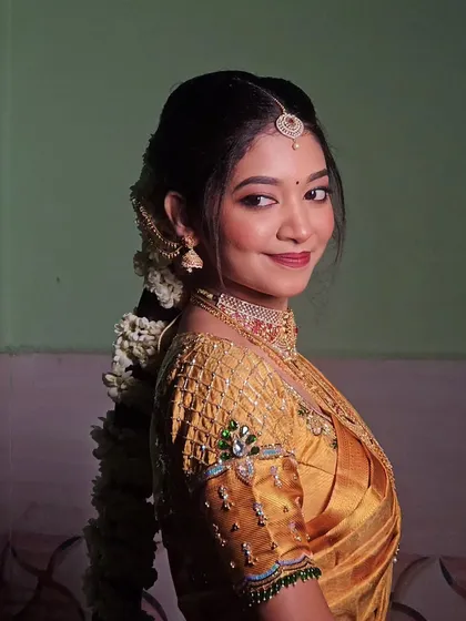 This bride is glowing in her golden-yellow Kanjivaram saree. The makeup is traditional and elegant, perfect for her temple wedding.